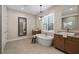 Stunning bathroom with freestanding tub, dual vanities, modern fixtures and shuttered window at 4670 Antrim Dr, Sarasota, FL 34240