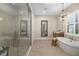 Elegant bathroom featuring a glass shower, soaking tub, and stylish vanity with chandelier lighting at 4670 Antrim Dr, Sarasota, FL 34240