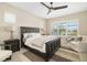 Bright bedroom featuring a king bed, ceiling fan, large windows, and comfortable chair at 4670 Antrim Dr, Sarasota, FL 34240