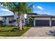 Exterior elevation showcasing lush landscaping and the home's three-car garage at 4670 Antrim Dr, Sarasota, FL 34240