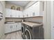 Well-organized laundry room with modern washer and dryer, ample cabinet space, and a functional countertop at 4670 Antrim Dr, Sarasota, FL 34240