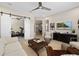 Spacious living room featuring a ceiling fan, media console, and view to home gym at 4670 Antrim Dr, Sarasota, FL 34240