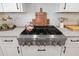 Close up of a stainless steel gas range with white cabinets and tile backsplash at 4670 Antrim Dr, Sarasota, FL 34240