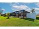 Lush backyard featuring a screened-in pool area, vibrant green grass, and surrounding privacy fencing at 5127 54Th W St, Bradenton, FL 34210