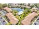 Aerial view of condo community with a swimming pool, a peaceful pond, lush greenery, and well-maintained landscapes at 5187 Lake Village Dr # 4, Sarasota, FL 34235