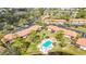 Aerial view features condo community with a swimming pool, a peaceful pond, and well-maintained landscapes at 5187 Lake Village Dr # 4, Sarasota, FL 34235