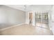 Bright bedroom with light-colored tile floors, ceiling fan, mirrored closet, and access to a private bathroom at 5187 Lake Village Dr # 4, Sarasota, FL 34235