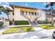 Inviting condo with a well-maintained facade, featuring dual staircases and lush green landscaping at 5187 Lake Village Dr # 4, Sarasota, FL 34235