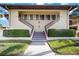 Charming condo with stairs leading to the units, surrounded by green landscaping and palm trees at 5187 Lake Village Dr # 4, Sarasota, FL 34235