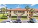 Condo building featuring a well-maintained exterior, palm trees, and convenient parking spaces at 5187 Lake Village Dr # 4, Sarasota, FL 34235