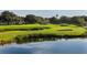 Scenic view of a lush golf course with sand traps and a serene pond reflecting the sky at 5187 Lake Village Dr # 4, Sarasota, FL 34235