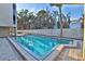 Refreshing swimming pool surrounded by a white fence, lush trees, and ample space for relaxation and recreation at 5611 Gulf Of Mexico Dr # 5, Longboat Key, FL 34228