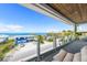 Balcony with seating and glass railings overlooking the street, beach, and ocean at 870 N Shore Dr, Anna Maria, FL 34216