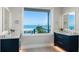 Bathroom featuring double vanities and a window with ocean views at 870 N Shore Dr, Anna Maria, FL 34216