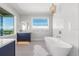 Elegant bathroom with soaking tub, marble wall, and window with a view at 870 N Shore Dr, Anna Maria, FL 34216