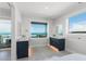 Bright bathroom with double vanities, tile flooring, and a large ocean-view window at 870 N Shore Dr, Anna Maria, FL 34216