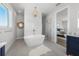 Luxurious bathroom with soaking tub, glass shower, and a view into the bedroom at 870 N Shore Dr, Anna Maria, FL 34216
