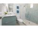 Stylish bathroom featuring a glass-enclosed shower with decorative blue tile, modern vanity, and sleek fixtures at 870 N Shore Dr, Anna Maria, FL 34216