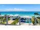 Stunning waterfront home featuring vibrant colors, a private beach, and a picturesque view of the bay and distant bridge at 870 N Shore Dr, Anna Maria, FL 34216