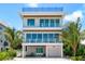 Stunning three-story home with palm trees and multiple balconies at 870 N Shore Dr, Anna Maria, FL 34216
