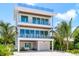 Beautiful three-story home with balconies and tropical landscaping at 870 N Shore Dr, Anna Maria, FL 34216