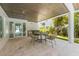 Inviting outdoor patio featuring a dining area, tiled floors, and access to a lush backyard space at 870 N Shore Dr, Anna Maria, FL 34216