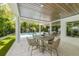 Charming outdoor patio featuring a dining area with a view of the pool and lush tropical landscaping at 870 N Shore Dr, Anna Maria, FL 34216
