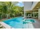 Stunning outdoor pool and patio area with lush tropical landscaping, ideal for relaxation and entertainment at 870 N Shore Dr, Anna Maria, FL 34216