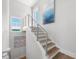 Modern staircase with wood treads, metal railings, and large windows providing ample natural light at 870 N Shore Dr, Anna Maria, FL 34216