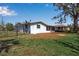 Back exterior view of a home featuring a screened-in porch and well-maintained lawn at 927 Lemon Bay Dr, Venice, FL 34293