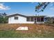 Back exterior view of a home featuring a screened-in porch and well-maintained lawn at 927 Lemon Bay Dr, Venice, FL 34293