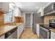 Traditional kitchen with stainless steel appliances, tile backsplash, white cabinets, and neutral countertops at 927 Lemon Bay Dr, Venice, FL 34293