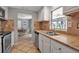 Galley kitchen featuring tile backsplash, stainless steel appliances, and neutral countertops at 927 Lemon Bay Dr, Venice, FL 34293