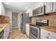 Kitchen featuring stainless steel appliances, tile backsplash, white cabinetry, and neutral countertops at 927 Lemon Bay Dr, Venice, FL 34293