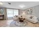 Bright living room with tiled floors, white seating, and large sunlit window at 927 Lemon Bay Dr, Venice, FL 34293