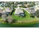 Aerial view of a well-maintained home featuring a screened-in pool and a lush green lawn on a lake at 13324 Purple Finch Cir, Lakewood Ranch, FL 34202