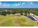 Expansive aerial view showcases a vast green field, small lake, and distant treeline under a bright, partly cloudy sky at 13324 Purple Finch Cir, Lakewood Ranch, FL 34202