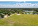 An aerial shot of a large park with trees, green fields, a small lake, and a basketball court at 13324 Purple Finch Cir, Lakewood Ranch, FL 34202