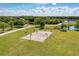 Overhead view of basketball court in green park with walking path under cloudy blue sky at 13324 Purple Finch Cir, Lakewood Ranch, FL 34202
