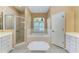Bright bathroom featuring a large soaking tub, walk-in shower, and neutral tile at 13324 Purple Finch Cir, Lakewood Ranch, FL 34202