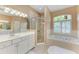 Bright bathroom featuring a large soaking tub, walk-in shower, and double vanity at 13324 Purple Finch Cir, Lakewood Ranch, FL 34202