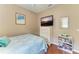 Charming bedroom with wood floors features a TV, dresser, and coastal decor at 13324 Purple Finch Cir, Lakewood Ranch, FL 34202