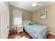 Cozy bedroom with wood floors features a ceiling fan, a window, and a comfortable bed at 13324 Purple Finch Cir, Lakewood Ranch, FL 34202