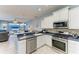 An open concept kitchen includes stainless appliances, a gas range, and breakfast bar seating at 13324 Purple Finch Cir, Lakewood Ranch, FL 34202