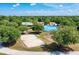 Overhead view of park with sand volleyball, rink and trees under blue sky at 13324 Purple Finch Cir, Lakewood Ranch, FL 34202