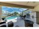 Relaxing screened-in patio includes a fire pit, dining table and overlooks the sparkling pool and peaceful lake at 13324 Purple Finch Cir, Lakewood Ranch, FL 34202