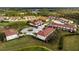 Aerial view of townhouses with red roofs and well-manicured landscaping around a pond at 2345 Felicity Pl, North Port, FL 34289