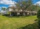 Exterior view of a two-story home with a lush green lawn and mature trees at 2345 Felicity Pl, North Port, FL 34289