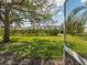 Well-manicured backyard with lush green grass and mature trees at 2345 Felicity Pl, North Port, FL 34289