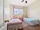 Bright bedroom featuring two beds, a colorful rug, and a window with a view at 2345 Felicity Pl, North Port, FL 34289